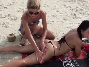 Завораживающая куколка делает подруге эротический массаж на пляже