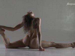 Гимнастка с тонкой талией демонстрирует свои таланты в обнаженном виде