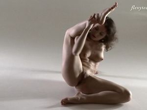 Гимнастка с тонкой талией демонстрирует свои таланты в обнаженном виде